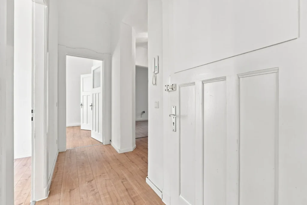 Flur einer Altbauwohnung mit Holzboden und weißen Kassettentüren